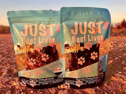 Two packages of 'Just Beef Liver' pet food on a dirt road.